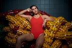 Maillot de bain une pièce rouge, technique et haut de gamme pour femme, porté de face, regard altier, esthétique luxueuse et haute couture. 